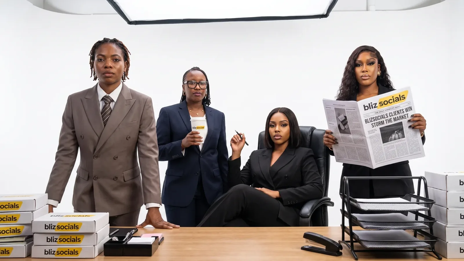 Four Blizsocials team members in a boardroom reviewing printed coverage and reports laid out in front of them